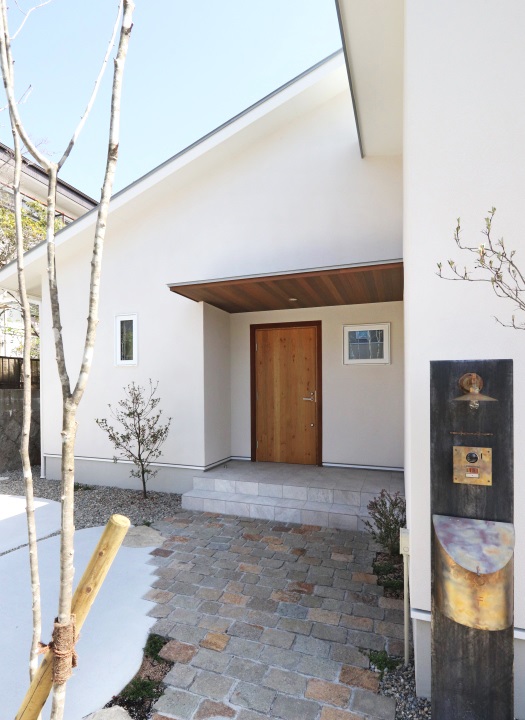 天然石のアプローチと木製玄関ドア